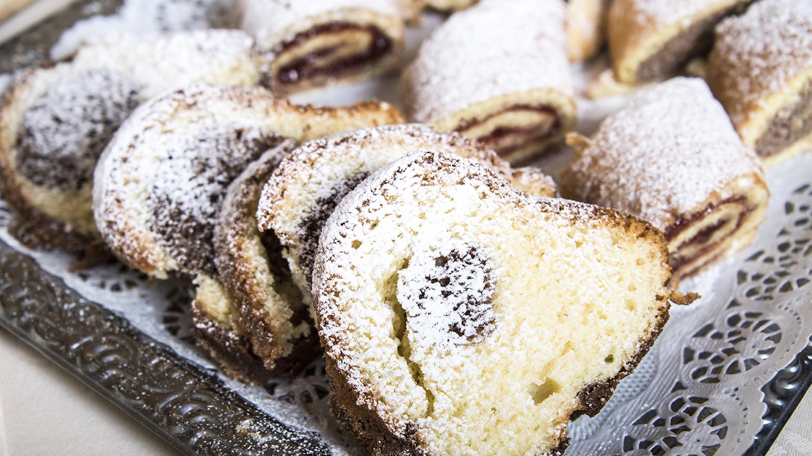 Various types of South Tyrolean desserts sprinkled with icing sugar