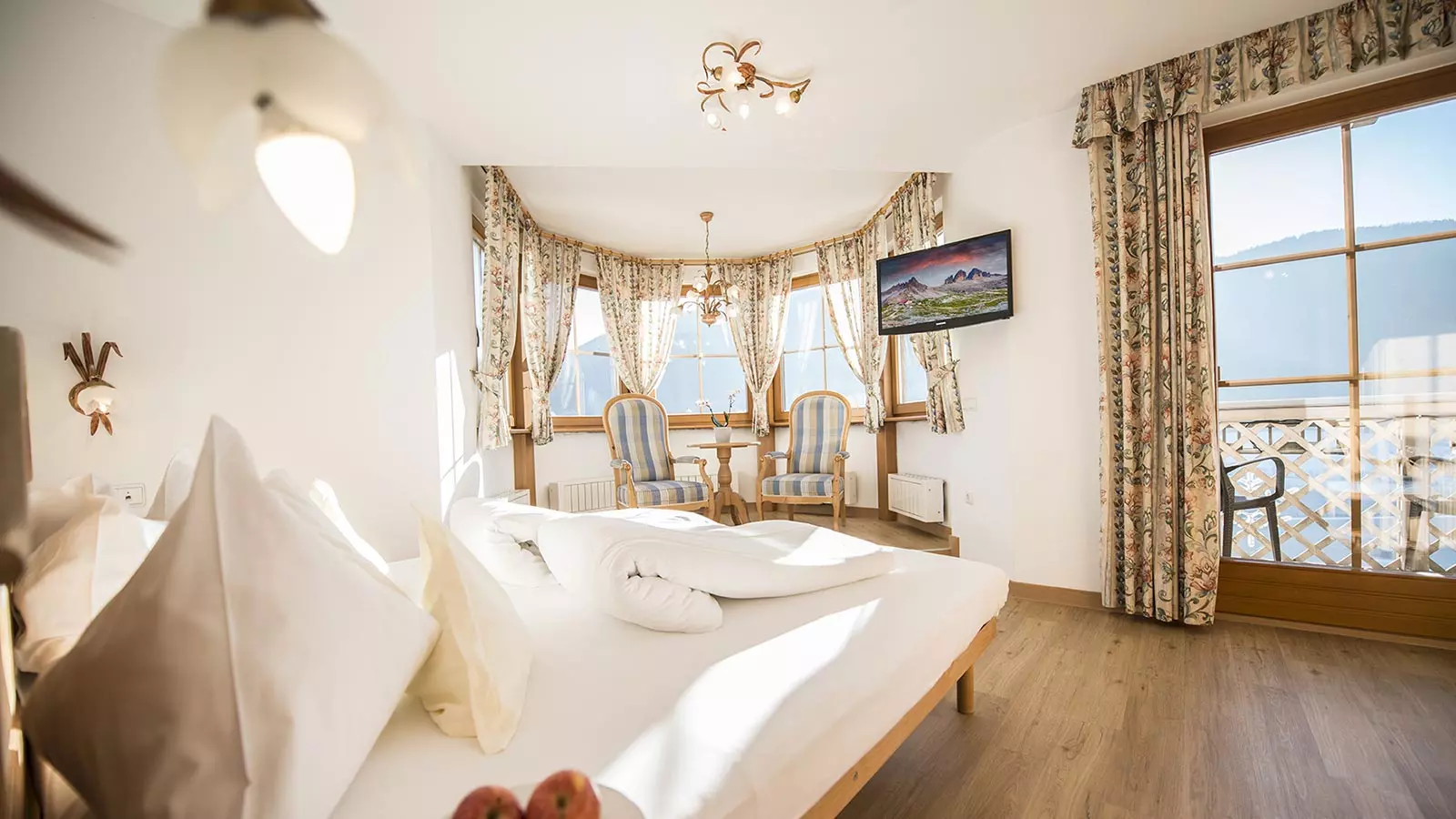 Elegante camera del nostro alloggio in Val Casies con raffinato arredamento di colore bianco e oro