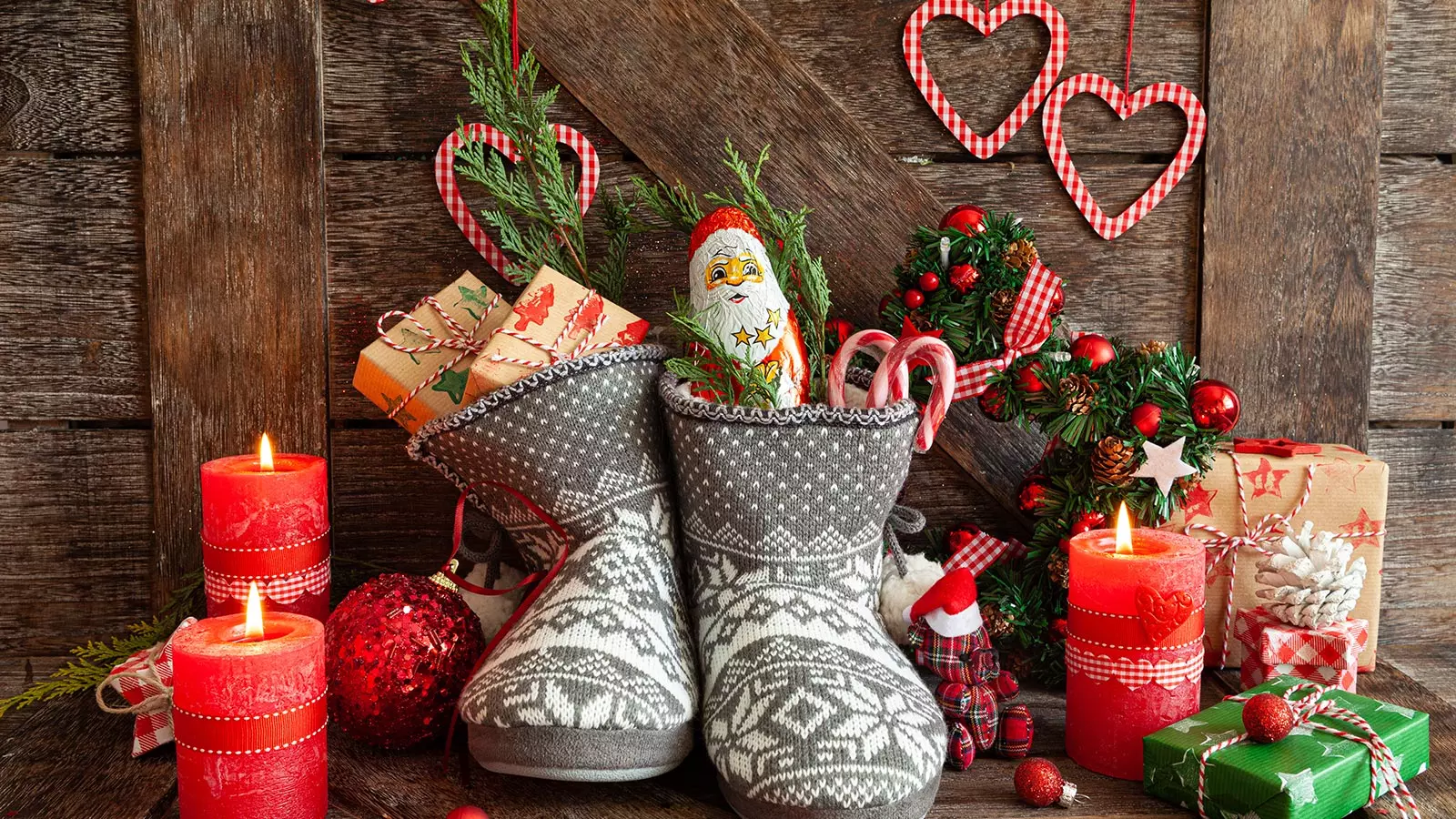 knitted slippers filled with sweets on a table decorated for Christmas